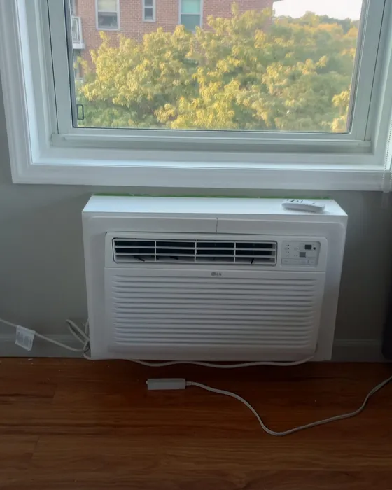 Wall air conditioner installed under a bedroom window