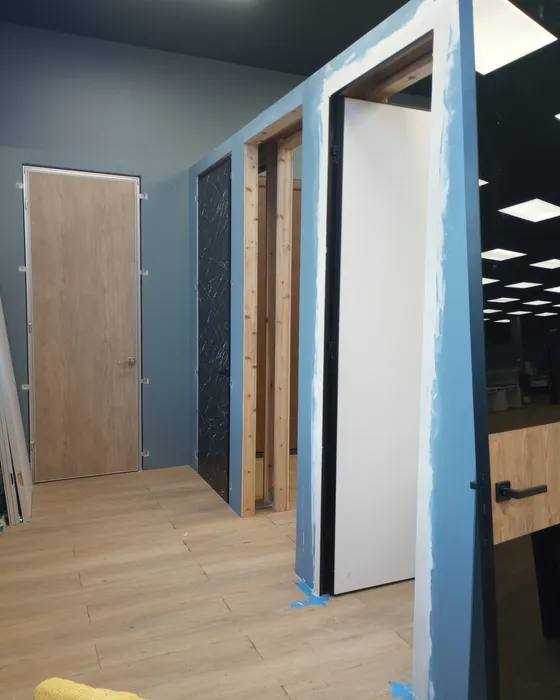 New interior door and frame installed beside a blue painted wall